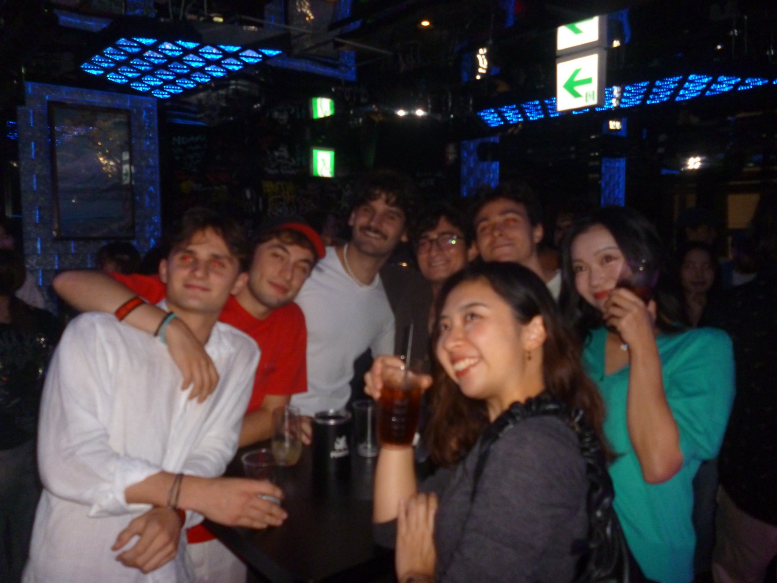 ドリンクを手に肩を組んで笑う学生たち / Students with drinks, arms around each other, laughing