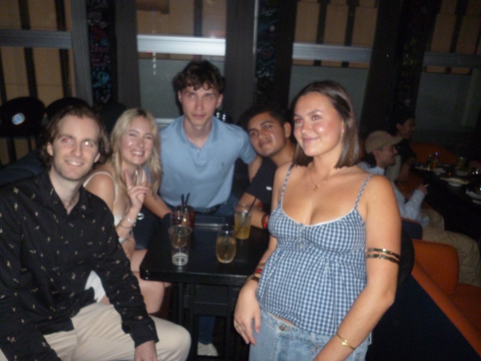テーブルを囲んでくつろぐ留学生と学生 — Students relaxing together around a bar table